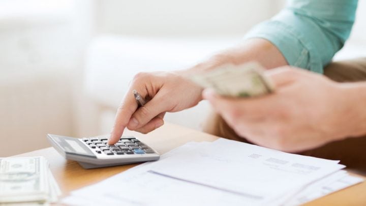 persona con calculadora y dinero en la mano